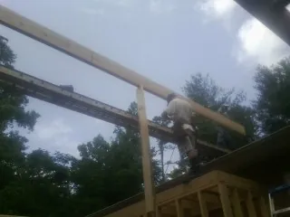 Carpenter setting a ridge beam over a new addition frame — Ice Dam Removal by Roofing Brothers in Somerset