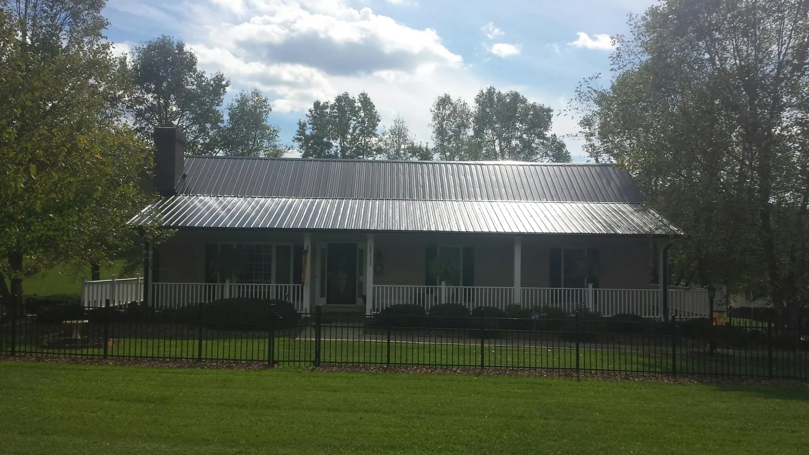 Gray metal roof on a brick ranch with a full width front porch — Gutter Guard Installation work by our crew in Somerset